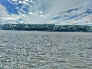 Scenic view of river against cloudy sky