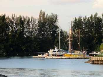 Sailboats moored in lake against sky