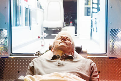 Close-up of patient lying on hospital gurney by ambulance