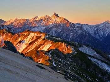 Snow covered mountain against sky during sunset