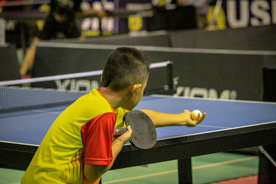 Side view of boy playing table tennis during competition