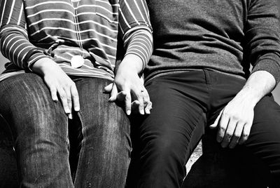 Midsection of couple holding hands