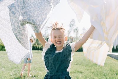 Girl running through the washing on a line in the garden having fun