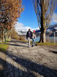 Rear view of people walking on road