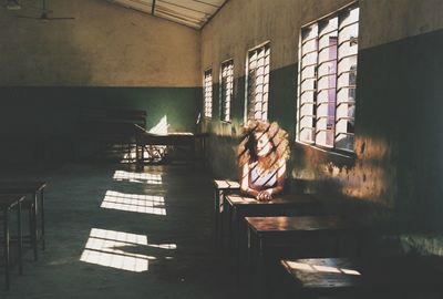 Woman sitting on chair in corridor