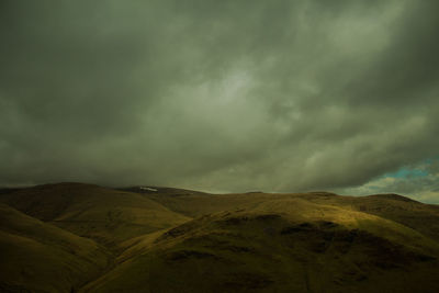 Scenic view of mountains against cloudy sky