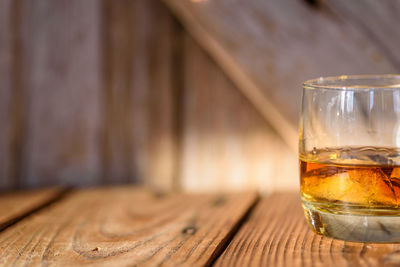 Close-up of whiskey in glass on wooden table