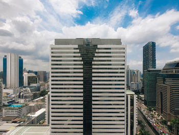 Modern buildings in city against cloudy sky