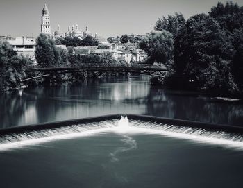 River amidst trees against saint front cathedral in city