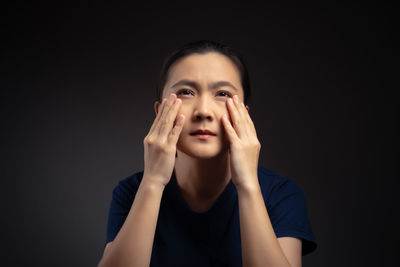 Portrait of a beautiful young woman over black background