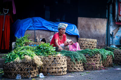 Portrait of woman with vegetables for sale at market