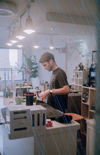 Side view of young man standing in restaurant