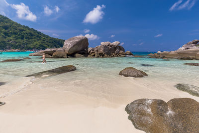 Rock formation on beach against sky