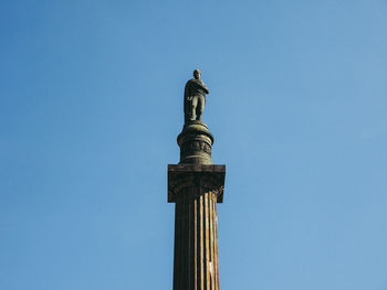 Low angle view of statue against blue sky