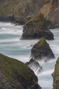 Scenic view of rocks in sea against sky