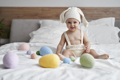 Portrait of cute baby boy lying on bed at home