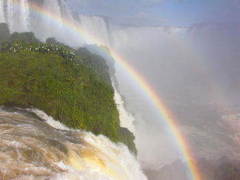 Scenic view of rainbow over sea against sky