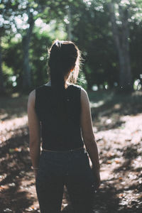 Rear view of young woman standing at park