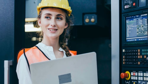 Young engineer using laptop at factory