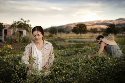 Male and female farmers working on field