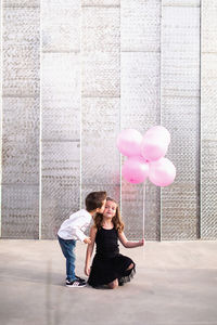 Full length of woman sitting with balloons