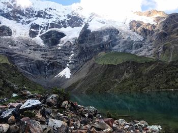 Scenic view of glacier by mountain against sky