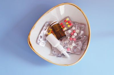 High angle view of pills in container on blue background