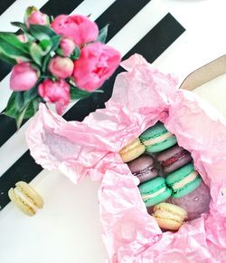 Directly above shot of macaroons and flowers on table