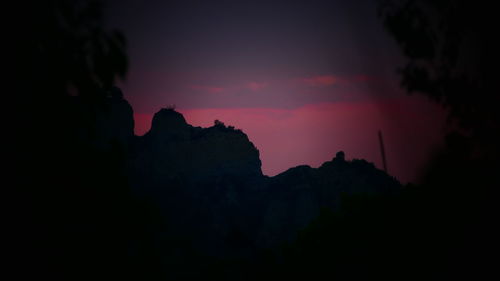 Silhouette mountains against sky at night