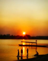 Silhouette of people at beach during sunset