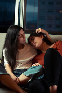 Smiling lesbian couple sitting on sofa