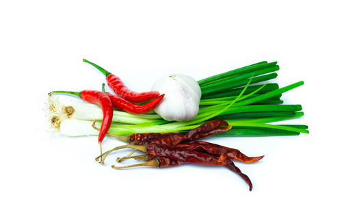 Close-up of spices and scallions over white background