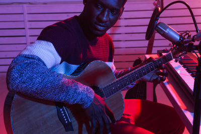 Portrait of young man playing guitar