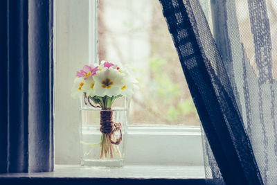 Close-up of flower vase on window sill