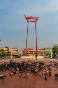 View of birds perching on metal structure against sky