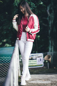 Smiling young woman standing wall