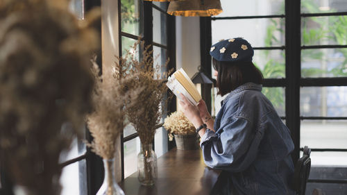 Side view of woman reading book