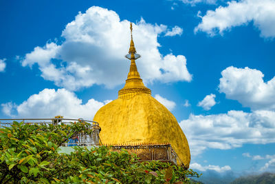 Low angle view of yellow bell tower against sky