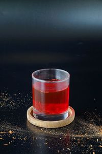 Close-up of tea in glass on table against black background