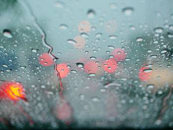 Selective focus of rain on the windshield of a car on a rainy day - driver's perspective