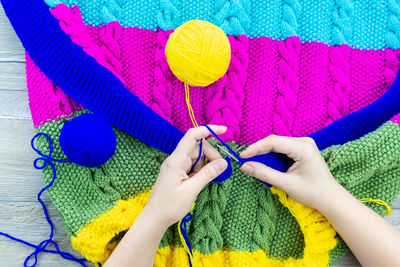 Midsection of woman holding multi colored clothing