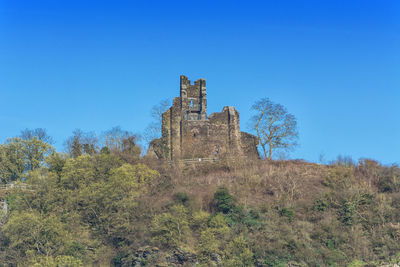 Low angle view of old building against clear blue sky