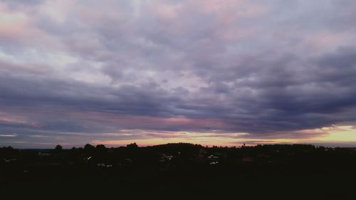 Scenic view of dramatic sky over silhouette landscape