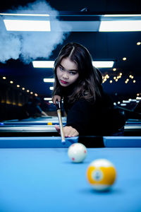 Young woman playing pool