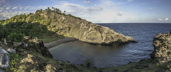 Rock formations by sea against sky