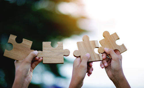 Cropped hands of woman holding jigsaw puzzle