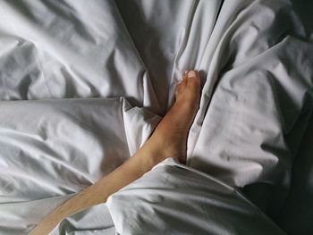 Midsection of woman lying on bed