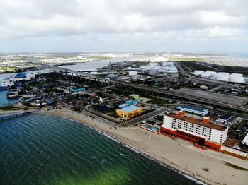 High angle view of cityscape by sea against sky