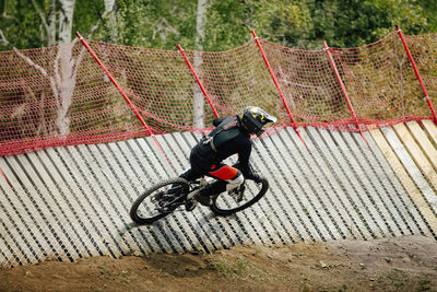 Man riding bicycle on fence