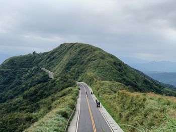 Mountain road against cloudy sky